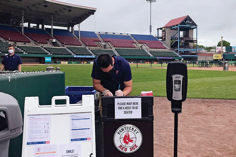 A worker prepares for guests to dine Wednesday on the field at McCoy Stadium, home of the Pawtucket Red Sox, in Pawtucket, R.I. The Triple-A affiliate of the Boston Red Sox has found another use for its home field, allowing diners to sample typical ballpark fare on the infield.