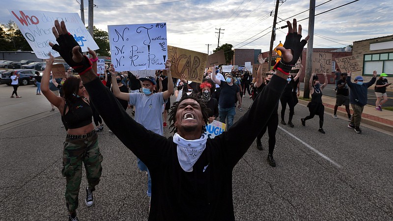 Protesters march on South Florissant Road in front of the Ferguson police station on Saturday, May 30, 2020, demonstrating against the death of George Floyd in custody of Minneapolis police officers. (Robert Cohen/St. Louis Post-Dispatch via AP)