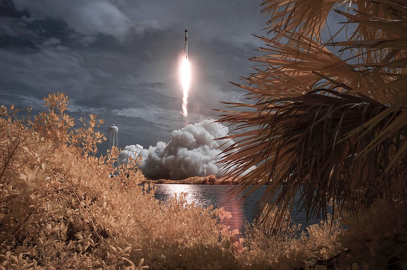In this photo provided by NASA, a SpaceX Falcon 9 rocket carrying the company's Crew Dragon spacecraft is seen in this false color infrared exposure as it is launched on NASA's SpaceX Demo-2 mission to the International Space Station with NASA astronauts Robert Behnken and Douglas Hurley onboard, Saturday, May 30, 2020, at NASA's Kennedy Space Center in Cape Canaveral, Florida. (Bill Ingalls/NASA via AP)