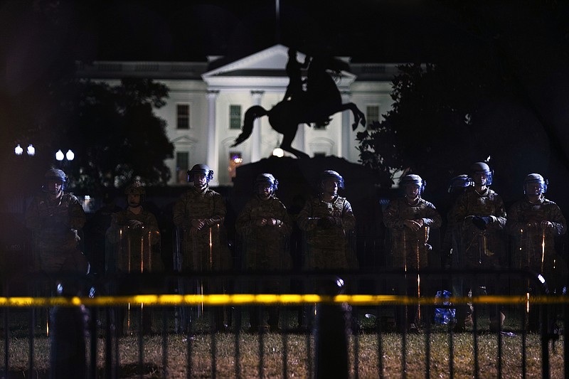 With the White House in the background, a line of police forms behind a fence in Lafayette Park as demonstrators gather to protest the death of George Floyd, Tuesday, June 2, 2020, in Washington. Floyd died after being restrained by Minneapolis police officers. (AP Photo/Evan Vucci)