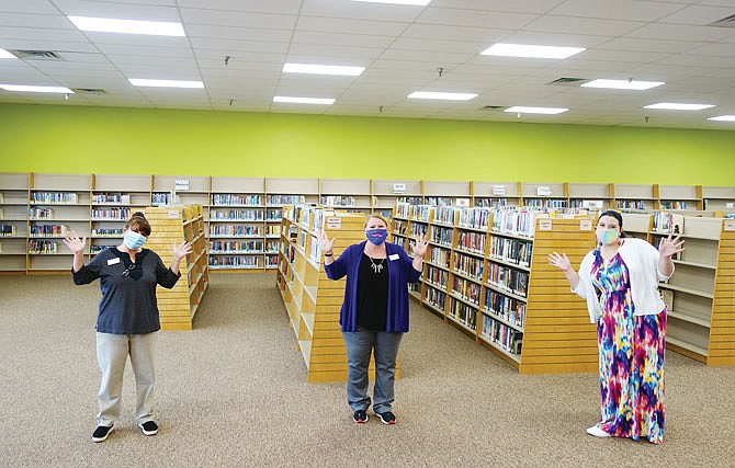 Holts Summit Public Library workers Tracy Schmitt, left, Pam Stone and Lisa Stock cheer for the passage of Proposition L. The increased library levy will help more than double the hours the library is open each week. "For as long as I've lived here, we've had a need for a library here," Stone said.