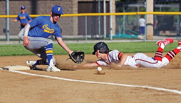 Jefferson City's Taylor Hopkins slides into third base as Fatima's Jake Boyce goes down to retrieve the throw during the first game of Thursday night's doubleheader in Westphalia.