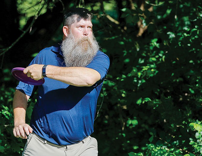 Eric Weddle winds up for a throw Saturday while practicing before the Jefferson City Disc Golf Membership Tournament at the Joseph C. Miller Disc Golf Course in Apache Flats. 