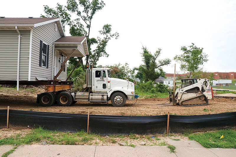 With the use of a tractor and skidsteer, the Jonassen Structural Movers trio team moves the Habitat for Humanity House originally at 409 Stadium Blvd. closer to Jackson Street, where it will be officially relocated Thursday.