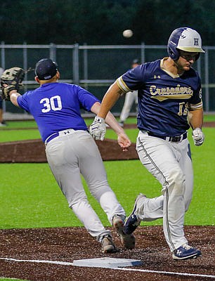 Capital City first baseman Jamisen Schwarzer reaches for the ball just as Helias' Jacob Watson makes it safely to first base during the second game of Tuesday night's doubleheader at Capital City High School.