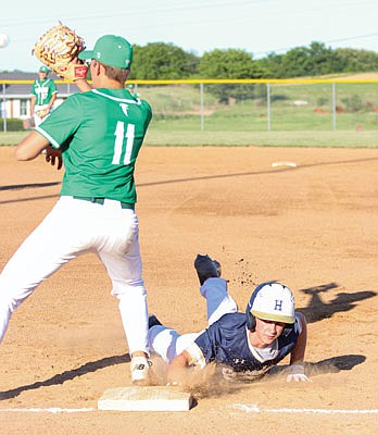 Alex Loethen of Helias dives back to first base as Gavin Wekenborg of Blair Oaks waits for a throw Thursday night at the Falcon Athletic Complex in Wardsville.