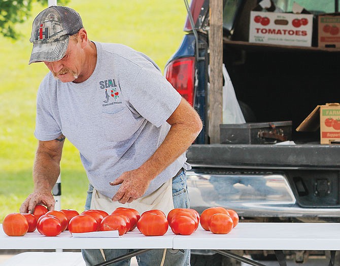 Pat Hayes, of SEAL Plants and Produce, rearranges the tomatoes he has left Friday during the Cole County Farmers' Market at Capital Mall. The Cole County Farmers Market takes place from 4-6 p.m. every Tuesday and Friday, and 2-4 p.m. Saturdays.