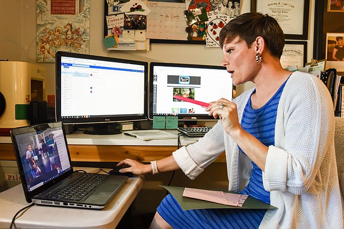 Belair Elementary School teacher Emily Roberts delivers an online art lesson as part of summer school classes. She has converted a craft room into her office from which she contacts her students and fellow teacher.