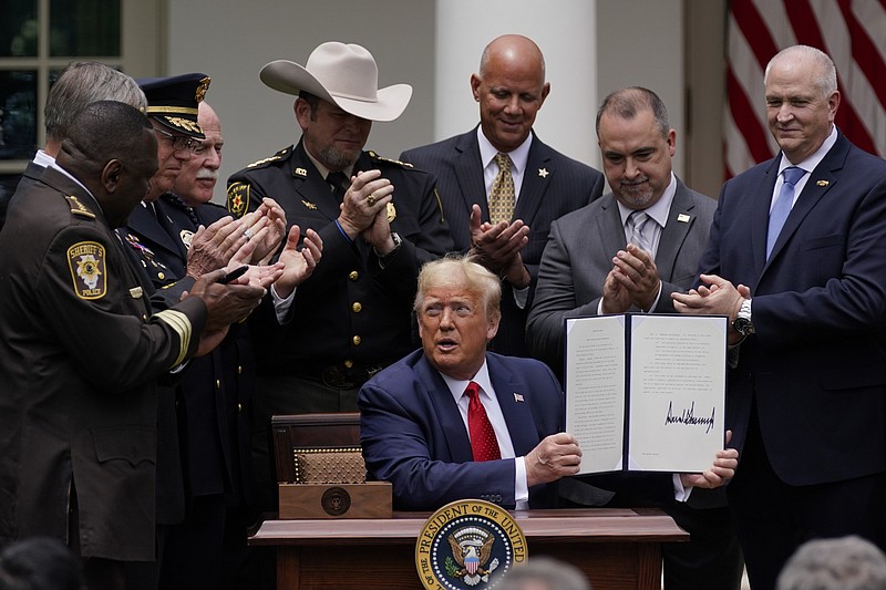 Law enforcement officials applaud after President Donald Trump signed an executive order on police reform, in the Rose Garden of the White House, Tuesday, June 16, 2020, in Washington.