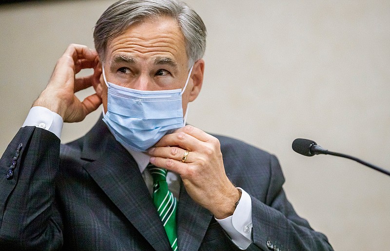 Texas Gov. Greg Abbott adjusts his mask after giving an update on the categories of medical surge facilities and how it effects Level 5 of maintaining staffed beds during a press conference at Texas Department of Public Safety, Tuesday, June 16, 2020, in Austin, Texas. (Ricardo B. Brazziell/Austin American-Statesman via AP)
