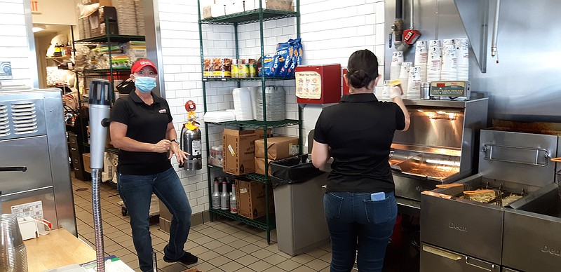 Sarah Harvey, left, general manager of Mooyah Texarkana, works on the lunch rush with Star Moya. Harvey says that after those first two weeks of the shutdown, customers began lining up for their burgers. She believes that among other things, the shutdown made customers want to try new things.