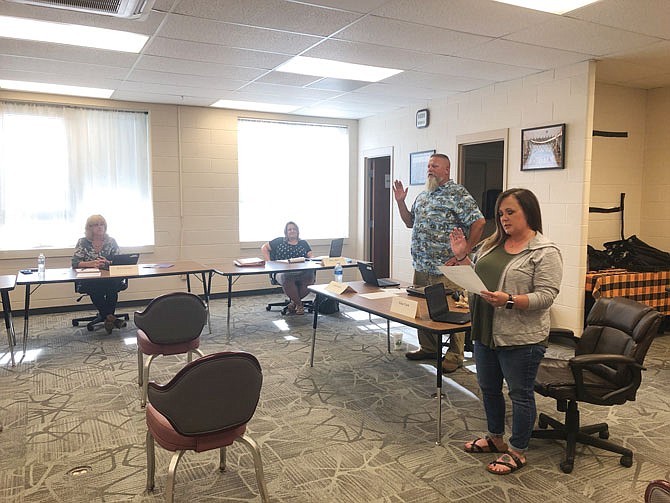 New Bloomfield R-3 School District Board of Education members Josh Woods, standing left, Gina Clark, right, and Angie Robinson Sullivan were sworn in Tuesday, June 16, 2020.