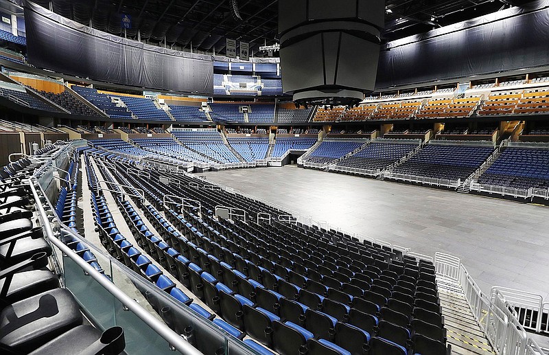 This is a March 12, 2020, file photo showing empty seats at the Amway Center in Orlando, home of the NBA's Orlando Magic. Most teams and leagues are reticent to discuss the fallout, but during a conference call with players, NBA commissioner Adam Silver told players that 40 percent of the league's revenue comes from ticket sales and in-arena purchases. The NBA makes about $1.2 million in gate revenue for each regular-season game played with fans, and there were 259 games remaining when the season was suspended. (Stephen M. Dowell/Orlando Sentinel via AP, File)