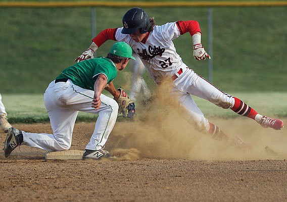 Taylor Hopkins of Jefferson City leaps into the air in an attempt to avoid getting tagged out by Blair Oaks shortstop Lane Libbert during Thursday night's doubleheader at the Falcon Athletic Complex in Wardsville.