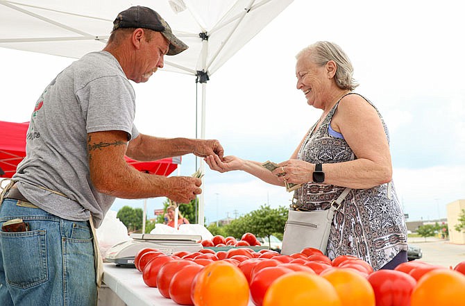 Pat Hayes, left, gives change back to Evelyn Slinkard for a purchase of tomatoes Friday during the Cole County Farmer's Market in the Capital Mall parking lot. Four booths were available at the market, which ran from 4-6 p.m.