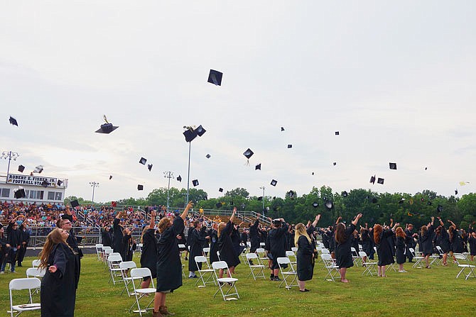 Backed by the setting sun, graduates in Fulton High School Class of 2020 toss their caps into the air. The FHS ceremony, a month later than originally planned due to the coronavirus, saw 155 students graduate. Graduates were spaced 6 feet apart during Friday's ceremony.