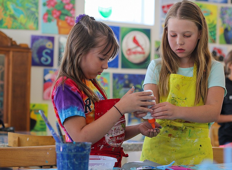 Lyla Harding, 9, left, gets help from her sister Macey Harding, 11, in gluing a pebble to her whale art on Tuesday during an art camp at Art 101. Macy said she's been doing art camps at Art 101 for a little while now and has loved it. 