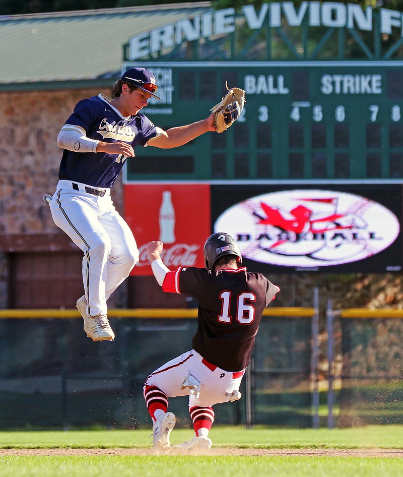Helias shortstop Trevor Austin leaps in an attempt to catch a throw as Grant Straub of the Jays slides into second base during Tuesday's doubleheader at Vivion Field.