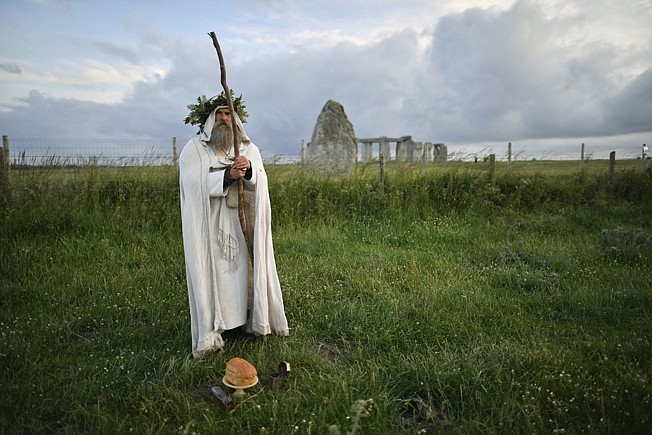 An Archdruid performs a ritual near the cordoned off Stonehenge.
