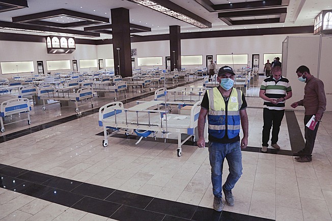 Workers set up a field hospital Saturday to treat patients with COVID-19 in Baghdad. New field hospitals have been erected to treat virus patients as hospitals reach capacity, but health workers fear the worst is still to come. 