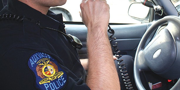 An officer with the Auxvasse Police Department talks over his radio system in this Fulton Sun file photo from June 2011.