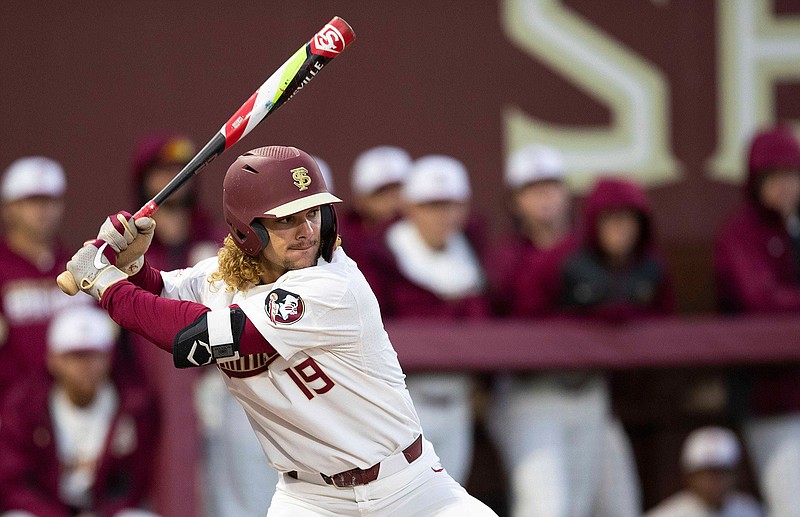 Florida State NCAA college baseball outfielder Elijah Cabell (19) bats against the Univ. of Cincinnati, Friday, Feb. 21, 2020, in Tallahassee, Fla. If all had gone as he hoped, Cabell and his Florida State teammates would be playing for the College World Series championship this week. Instead, Cabell treks to a ball field in his neighborhood in Winter Park, Florida, most days to work on his game in solitude.  (Alicia Devine/Tallahassee Democrat via AP)