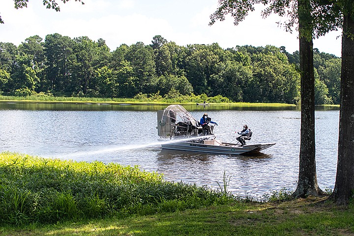 The Texas Parks and Wildlife Department sprays giant salvinia weeds Thursday, June 24, 2020, at Bringle Lake Park in Texarkana, Texas. Thomas Decker with the department said that the invasive species had to have been growing for years before they found out, and he is unsure they will be able to remove it all. The plant replaces native species and decreases oxygen in the water.