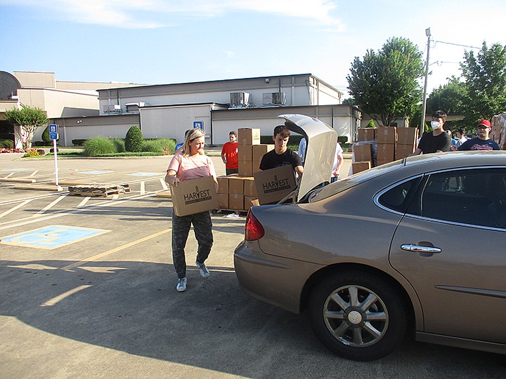 Volunteers load a car with food Wednesday, June 24, 2020, at First Baptist Church on Moores Lane in Texarkana. Staff photo by Greg Bischof
