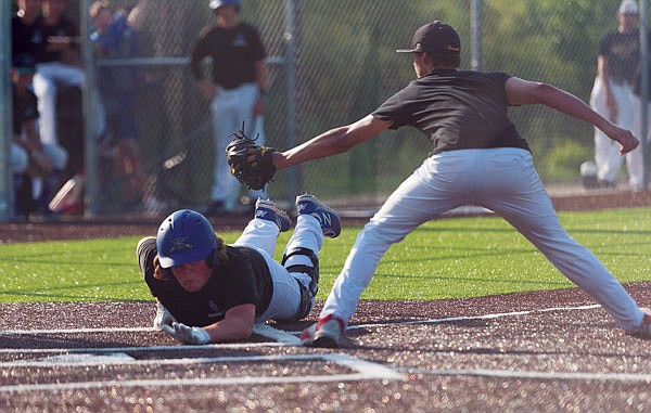 Ben Turner of Capital City slides safely under the tag attempt of Fulton's pitcher after a wild pitch in the bottom of the first inning in the first game of Thursday's doubleheader at Capital City High School.