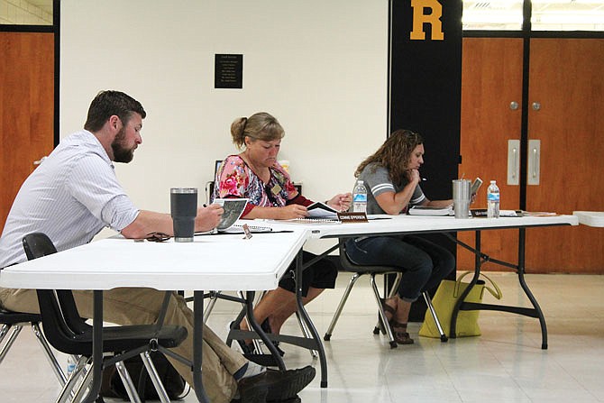 Fulton school board members look at plans for parking lot and drainage projects.
