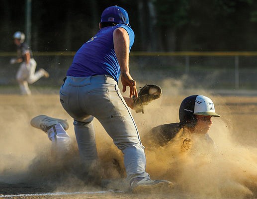 Peyton Huddleston of Helias slides into third base just a little too late as he's tagged out by Fatima third baseman Shane Verslues during the first game of Thursday's doubleheader in Westphalia.