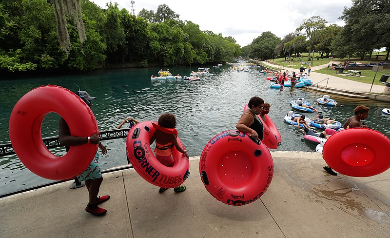 Tubers and swimmers, some wearing face masks to protect against the spread of COVID-19, prepare to float the Comal River, Thursday, June 25, 2020, in New Braunfels, Texas. Texas Gov. Greg Abbott said Wednesday that the state is facing a "massive outbreak" in the coronavirus pandemic and that some new local restrictions may be needed to protect hospital space for new patients. (AP Photo/Eric Gay)