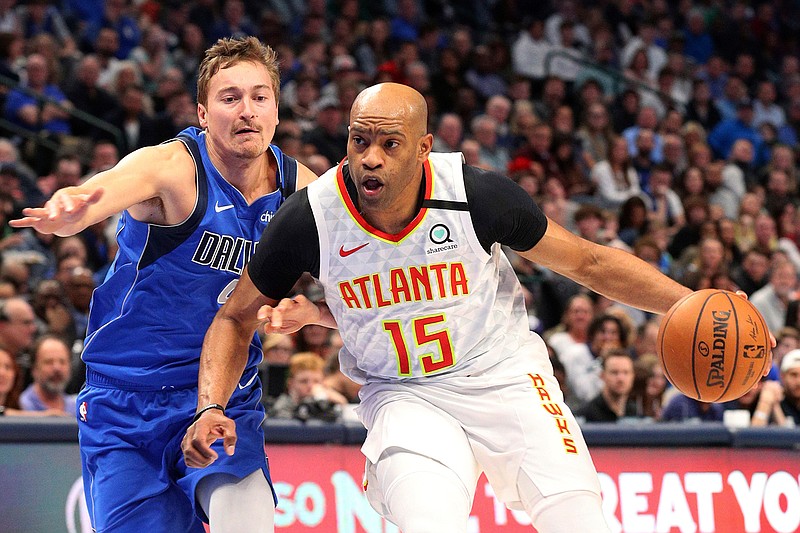 In this Feb. 1, 2020, file photo, Atlanta Hawks guard Vince Carter (15) drives to the basket against Dallas Mavericks guard Ryan Broekhoff (45) during the second half of an NBA basketball game in Dallas. Carter made his retirement official Thursday, June 25, 2020, announcing on his podcast that his 22-year NBA career has come to an end. The announcement was largely a formality, since the 43-year-old Carter had said many times over the course of this season that this would be his last in the NBA. His 22 seasons are the most in league history, and he became the first NBA player to appear in four different decades. (AP Photo/Richard W. Rodriguez, File