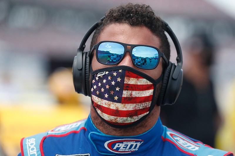 Driver Bubba Wallace walks to his car in the pits of the Talladega Superspeedway prior to the start of the NASCAR Cup Series auto race at the Talladega Superspeedway in Talladega Ala., Monday June 22, 2020. In an extraordinary act of solidarity with NASCAR's only Black driver, dozens of drivers pushed the car belonging to Bubba Wallace to the front of the field before Monday's race as FBI agents nearby tried to find out who left a noose in his garage stall over the weekend. (AP Photo/John Bazemore)