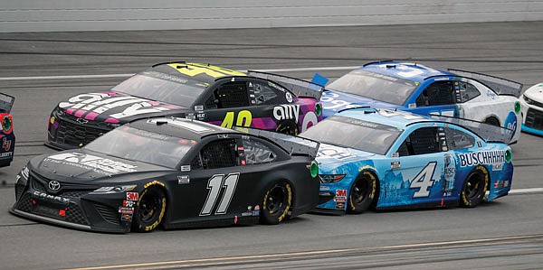 Denny Hamlin (11) takes the inside lane in front of Kevin Harvick (4) as Jimmie Johnson (48) keeps up during Monday afternoon's NASCAR Cup Series race at Talladega Superspeedway in Talladega, Ala.