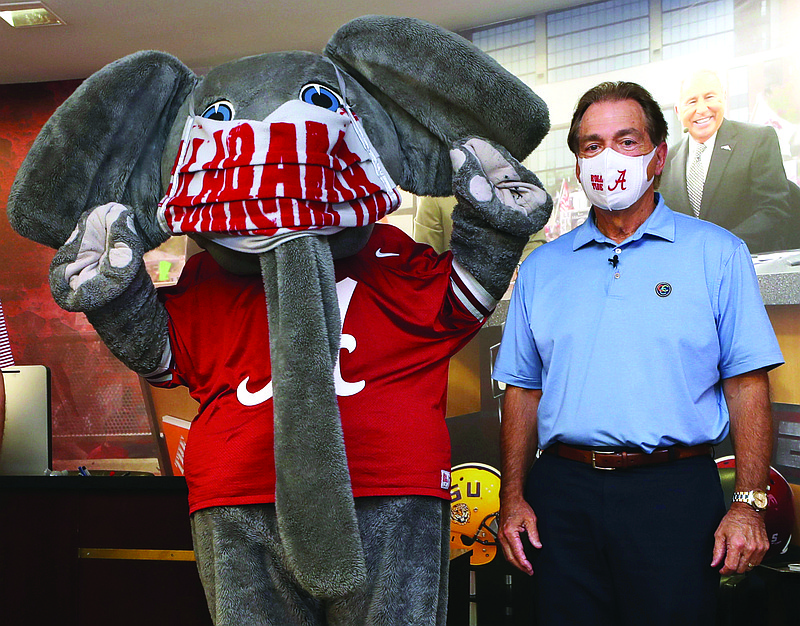 In this May 20 file photo provided by the University of Alabama, football head coach Nick Saban and the school's elephant mascot, Big Al, wear masks on the university campus in Tuscaloosa, Ala.