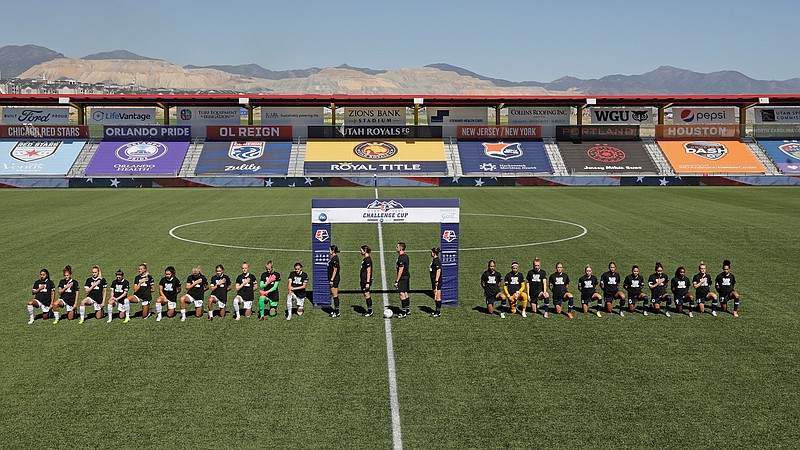 Players for the Portland Thorns, left, and the North Carolina Courage kneel during the national anthem Saturday, June 27, 2020, before the start of their NWSL Challenge Cup soccer match at Zions Bank Stadium in Herriman, Utah.