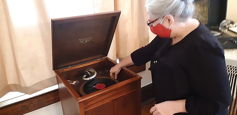 Jamie Simmons, curator of Texarkana Museum Systems, leads tours Saturday through the P.J. Ahern Home. She demonstrates a Victrola in the home's music room, showing both how such a device worked and what place it had in a house.