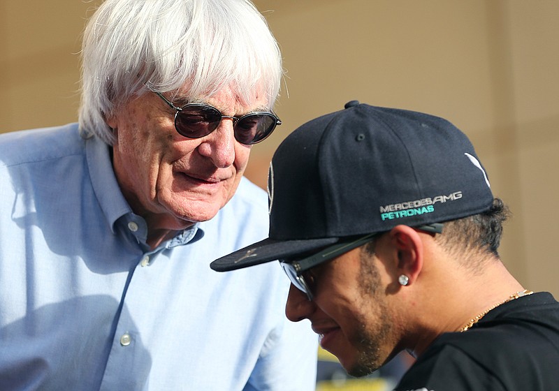 n this Thursday, April 16, 2015 file photo, Bernie Ecclestone, President and CEO of Formula One Management, left, talks to Mercedes driver Lewis Hamilton of Britain ahead the Bahrain Formula One Grand Prix at the Formula One Bahrain International Circuit in Sakhir, Bahrain. Formula One champion Lewis Hamilton has criticized "ignorant and uneducated" comments by former F1 boss Bernie Ecclestone. Hamilton, a six-time world champion and the only Black driver in F1, was shocked by Ecclestone's claim during an interview with broadcaster CNN on Friday, June 26, 202 that "in lots of cases, Black people are more racist" than white people. (AP Photo/Kamran Jebreili, File)