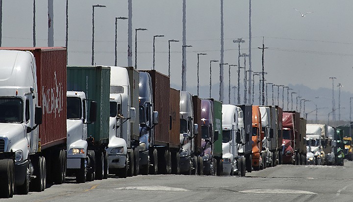 In this July 22, 2019 photo, trucks hauling shipping containers wait to unload at the Port of Oakland in Oakland, Calif.  The Commerce Department issues its second estimate of how the U.S. economy performed in the first quarter of 2020 on Thursday, May 28, 2020.(AP Photo/Ben Margot, File)