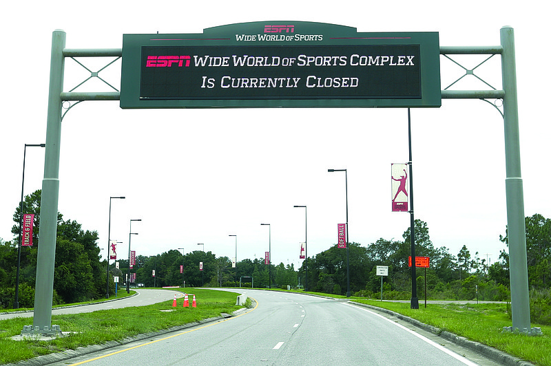 In this June 3 file photo, a sign at the entrance to ESPN's Wide World of Sports at Walt Disney World shows the complex is closed in Kissimmee, Fla.