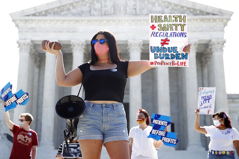 Terrisa Bukovinac, founder of Pro-Life San Francisco, holds a model of a fetus as she and other anti-abortion protesters wait outside the Supreme Court for a decision, Monday, June 29, 2020. The Supreme Court has struck down a Louisiana law regulating abortion clinics, reasserting a commitment to abortion rights over fierce opposition from dissenting conservative justices in the first big abortion case of the Trump era. (AP Photo/Patrick Semansky)