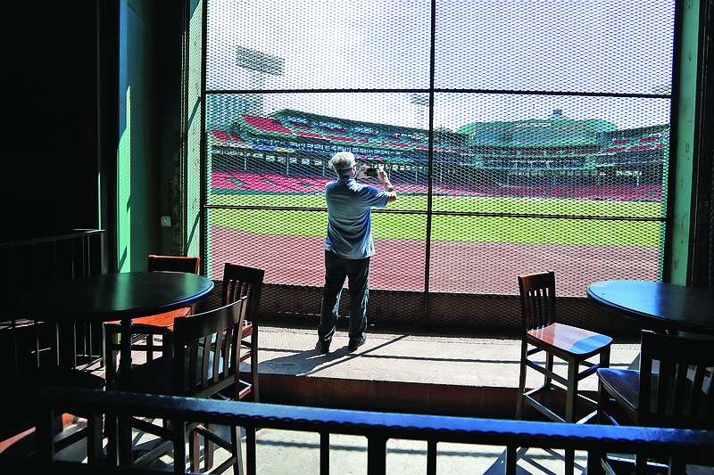 A reporter photographs the view of the baseball field last Thursday at Fenway Park from the Bleacher Bar in Boston.