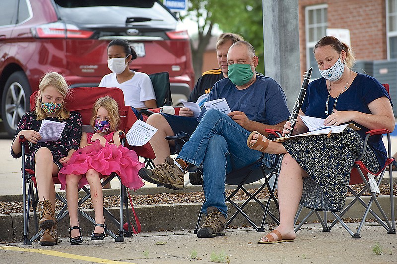 Parishioners of The Oasis United Church of Christ attend Sunday morning's worship service in a parking lot adjacent to the church.