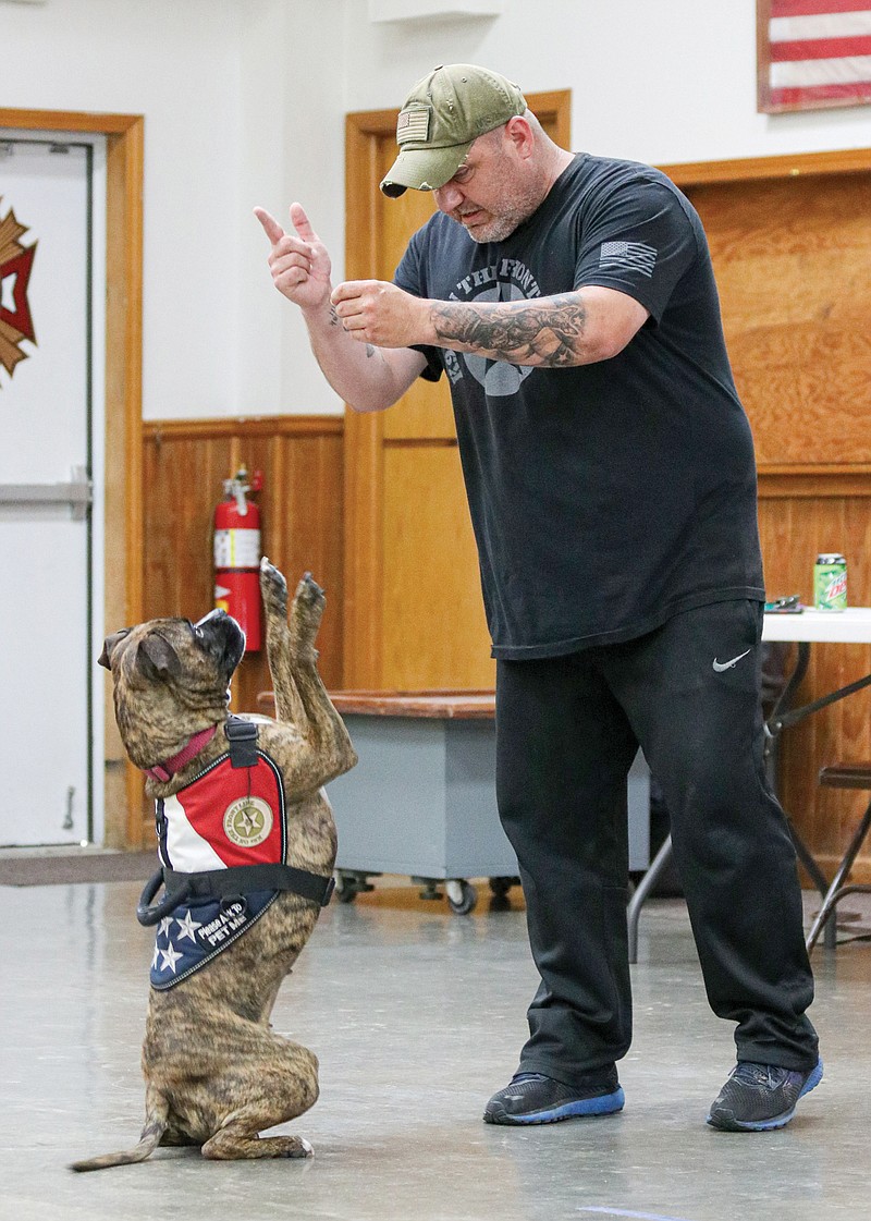 Jason Howe, K9s on the Front Line instructor, encourages his dog, Sobee, to perform a specific task with a treat June 22 during K9s on the Front Line training at Veterans of Foreign Wars Post 35 in St. Martins.