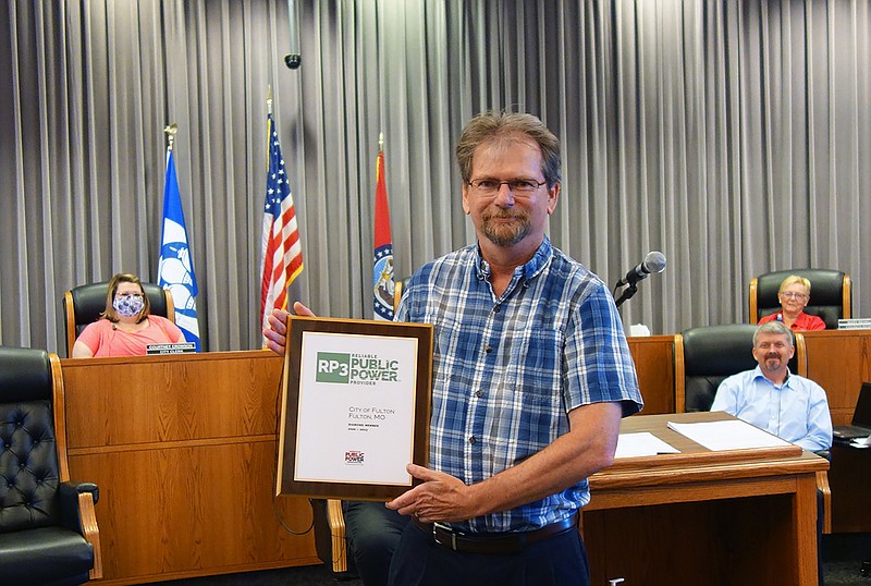 Utilities Supervisor Darrell Dunlap poses with a reliability award the city's electric department recently earned. The average city customer only experienced 23 minutes of outage in all of 2019.