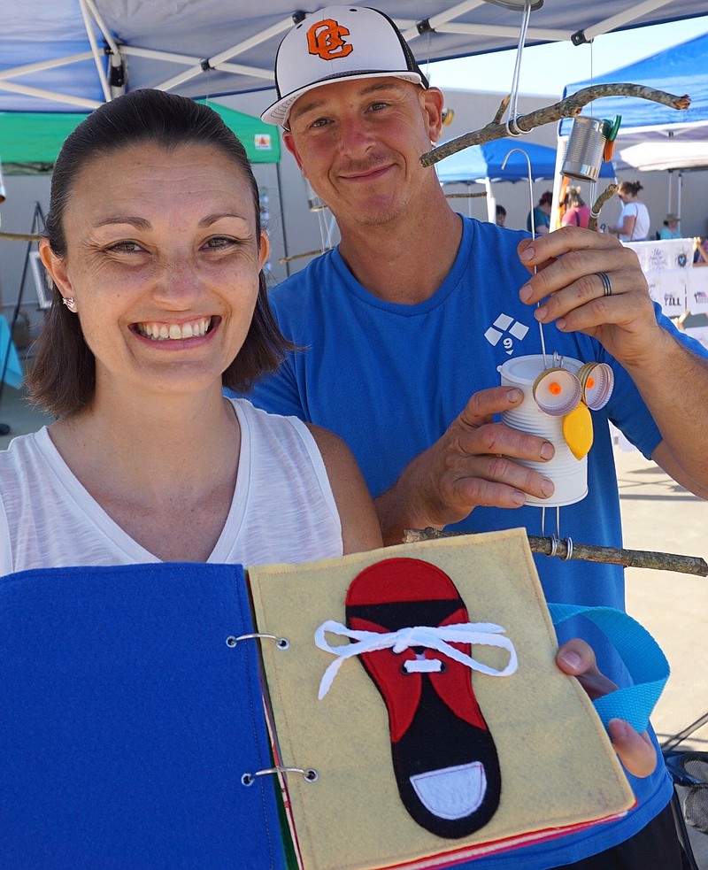  Becky Pickard shows the quiet books she makes by hand to teach fine-motor skills. Her husband, Donnie, shows the owls she likes to make from tin cans. The two were part of Atlanta's Local Makers Market recently.