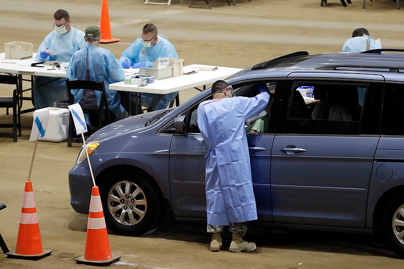 Workers administer COVID-19 tests at a drive-through facility set up in the Williamson County Agricultural Center, Thursday, July 2, 2020, in Franklin, Tenn. Tennessee Gov. Bill Lee issued a stern warning to the public Wednesday as Tennessee registered its highest daily increase in positive COVID-19 tests for the third time in a week and a half.