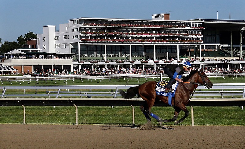 In this July 31, 2015, file photo, people watch as Triple Crown winner American Pharoah with Jorge Alvarez up trains at Monmouth Park in Oceanport, N.J. With the opening of the thoroughbred season at Monmouth Park just days away, chief executive Dennis Drazin knows the track will be beating the odds by just breaking even. The coronavirus pandemic has idled the New Jersey Shore track for two months. (AP Photo/Mel Evans, File)