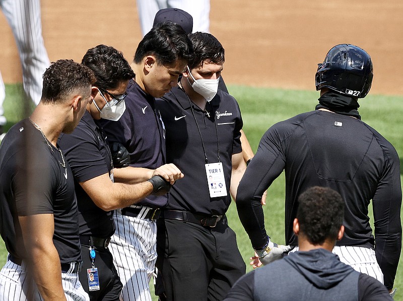 Masahiro Tanaka of the New York Yankees is helped off the field after he was hit in the head by a batted ball during summer workouts at Yankee Stadium in New York on Saturday, July 4, 2020. (Elsa/Getty Images/TNS)